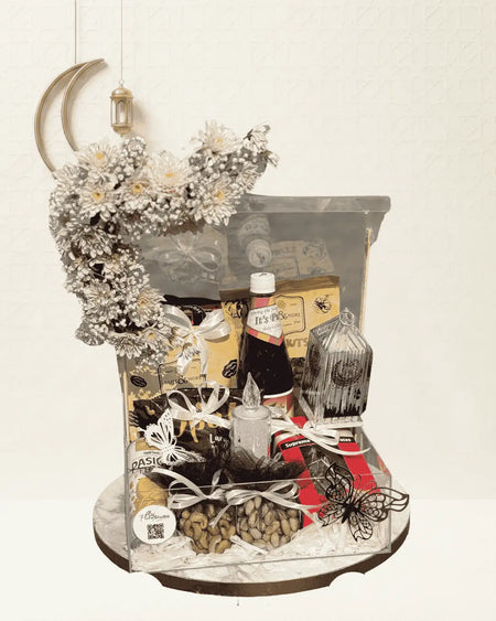 Decorative arrangement with a bottle, flowers, and other items on a white background