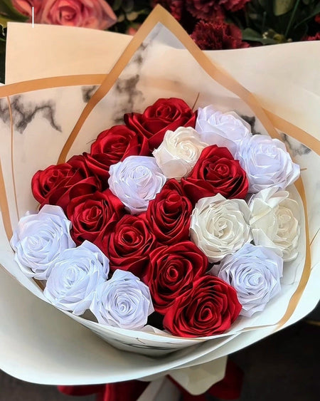 Bouquet of red and white roses in a decorative box with 'Floral Studio' branding.