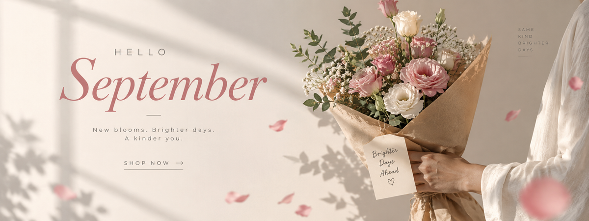 A person in a white dress holds a bouquet of pink and cream roses with green foliage, wrapped in brown paper, against a warm beige background with soft shadows and the text 'HELLO September'.
