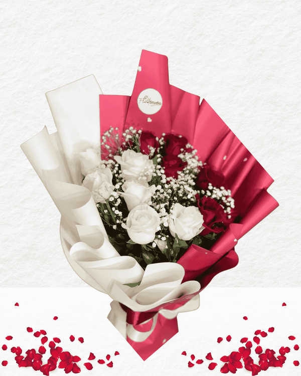 Bouquet of flowers wrapped in red paper with a white ribbon on a light gray background.