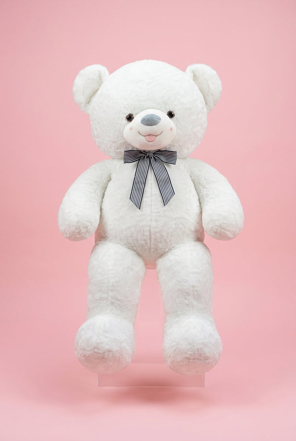 Large white teddy bear with a bow tie in a store setting with flowers and gift bags.