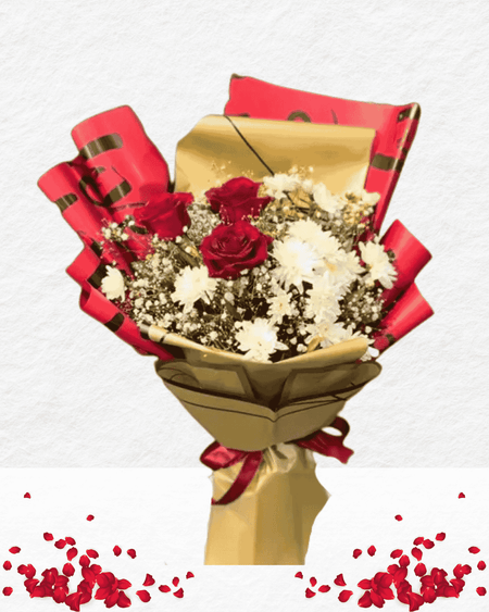Bouquet of red and white flowers wrapped in gold paper with red ribbons on a light gray background.
