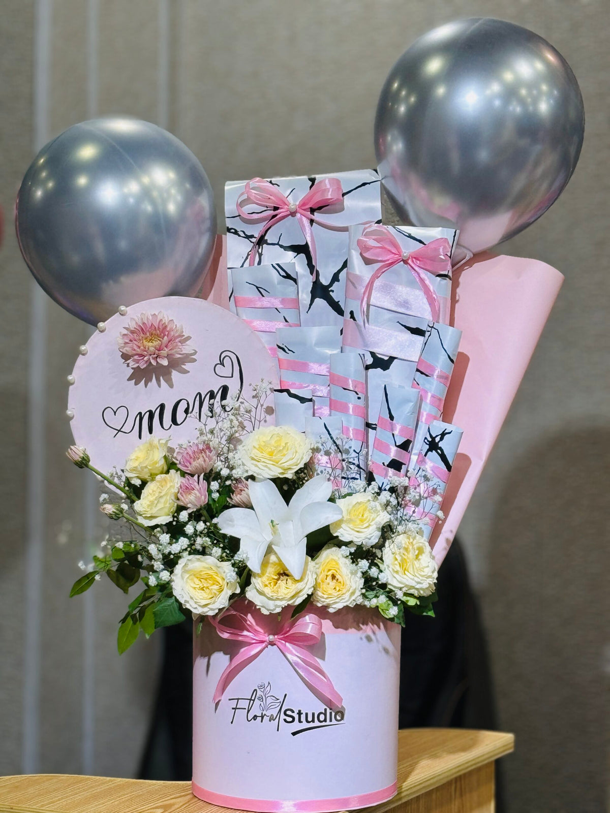 Best Mom Ever flower wrap with chocolates, white roses, baby’s breath, and lilies

