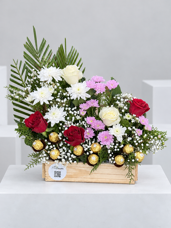 Red and white roses with Ferrero Rocher in a wooden crate by Floral Studio