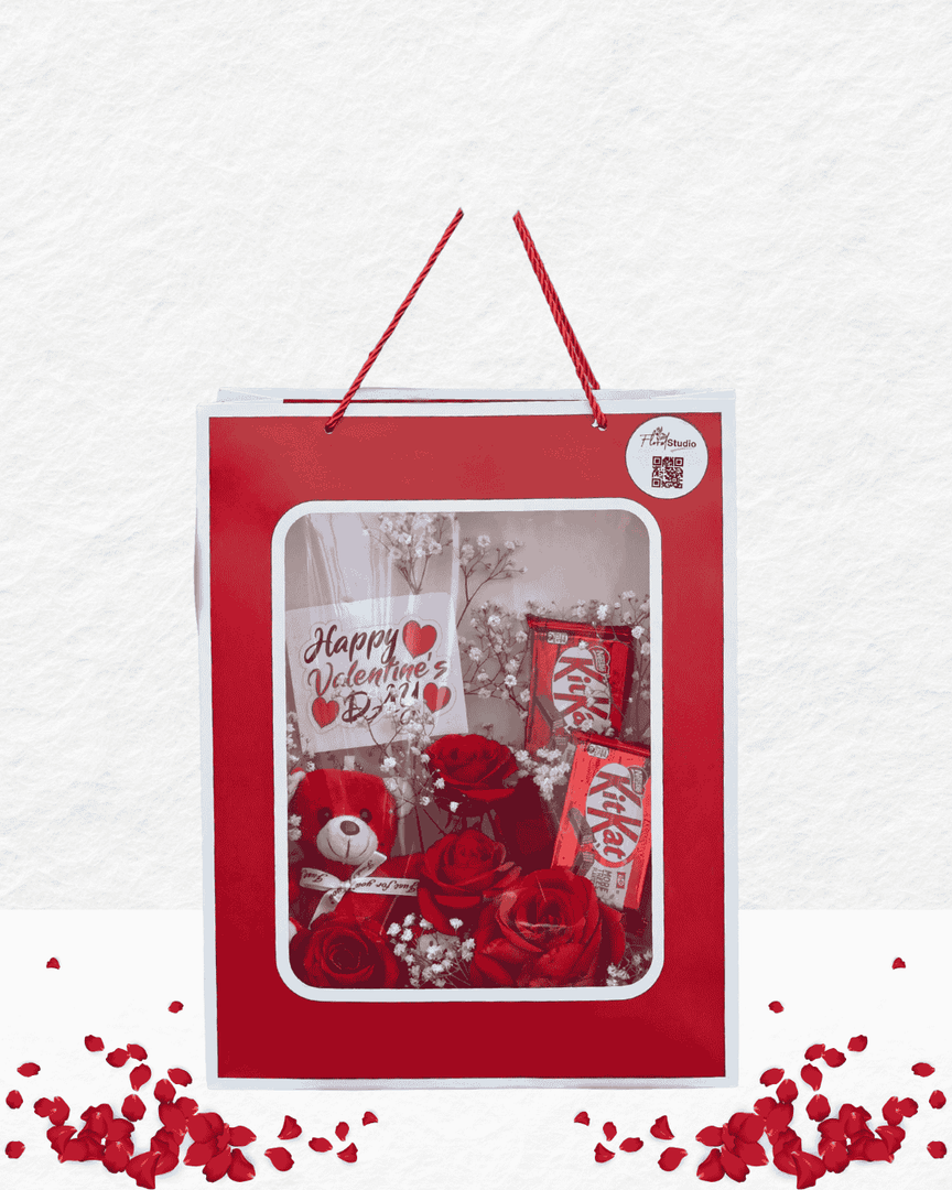 Valentine's Day gift set with red roses, KitKat bars, and a card in a red box on a white background.