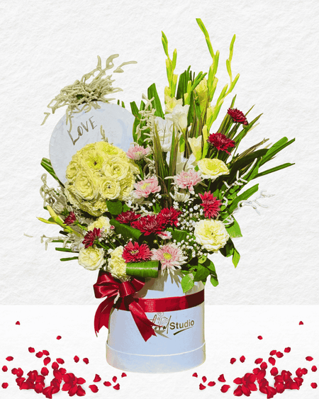 Bouquet of flowers in a box with a 'Love' sign on a white background
