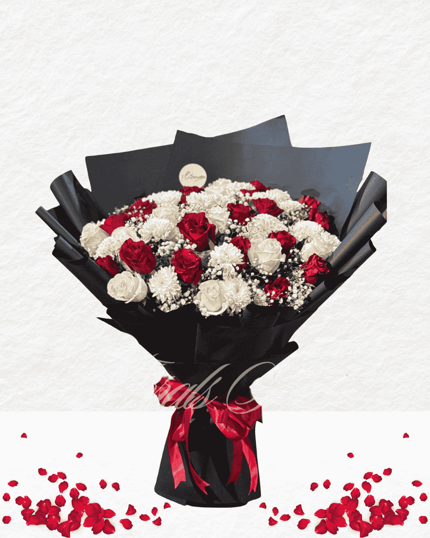Bouquet of red and white flowers wrapped in black paper with a red ribbon on a light gray background.