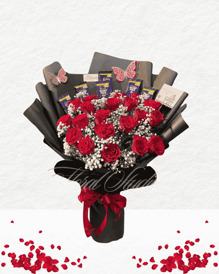 Bouquet of red roses shaped like a heart with chocolate bars and ribbons on a white background