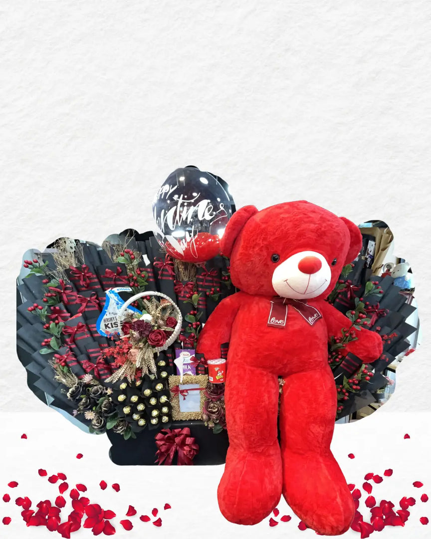 Red teddy bear in a decorative arrangement with flowers and gifts on a white background