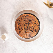 Chocolate marble cake with vanilla and chocolate swirls served on a plate with a cup and fork in the background
