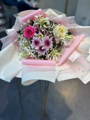Bouquet of rosses , baby birth & colorful  flowers wrapped in pink paper with ribbons 