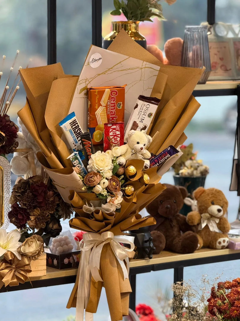 Bouquet of flowers with teddy bears and candy arranged in a decorative setting.