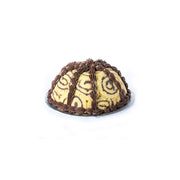 Dome-shaped ice cream bomb with praline ice cream topped with chocolate sauce on white background

