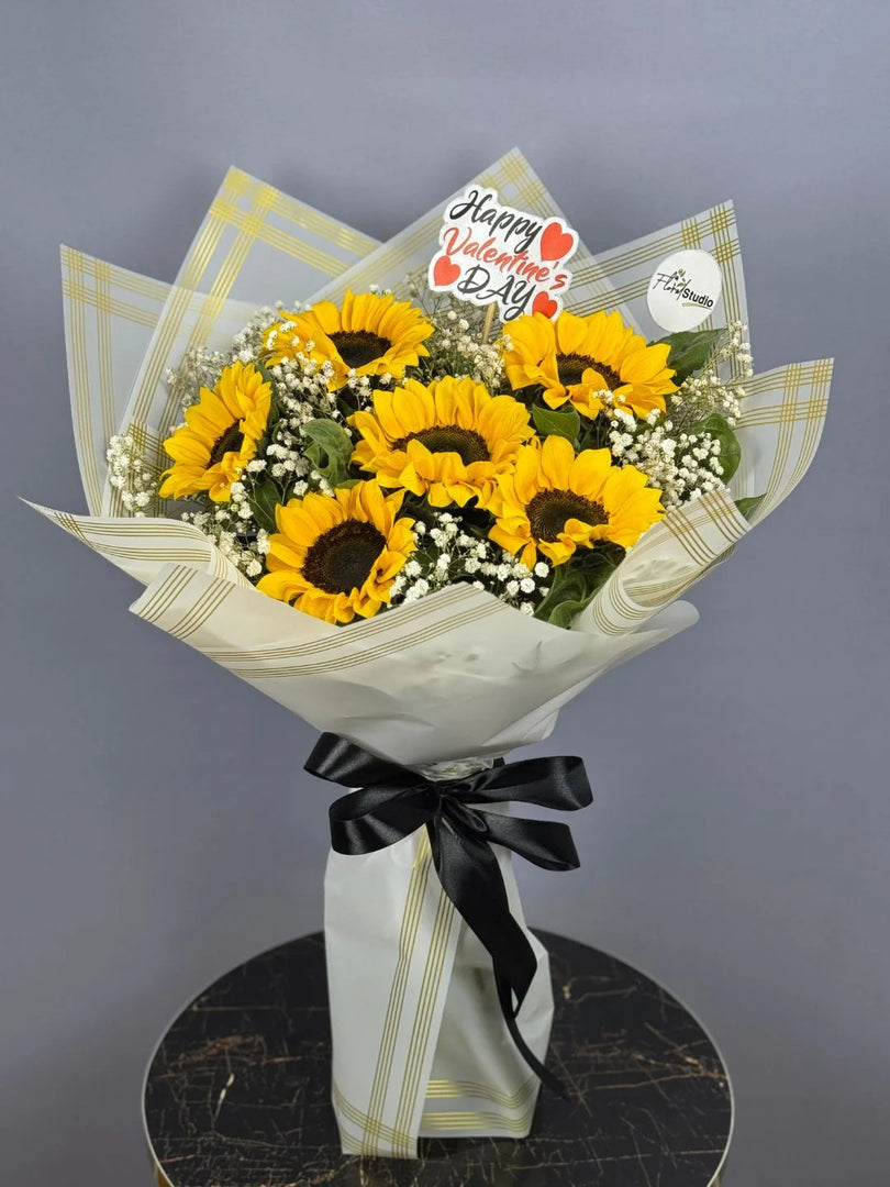 Bouquet of sunflowers with a 'Happy Valentine's Day' card on a gray background. Send flowers to lahore
