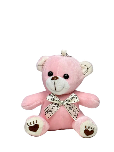 A small pink plush teddy bear with a bow ribbon around its neck.