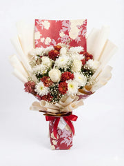 Bouquet of flowers wrapped in paper with a red ribbon on a white background