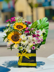 Bouquet of flowers with sunflowers and a yellow ribbon on a blurred background. Send flowers to lahore