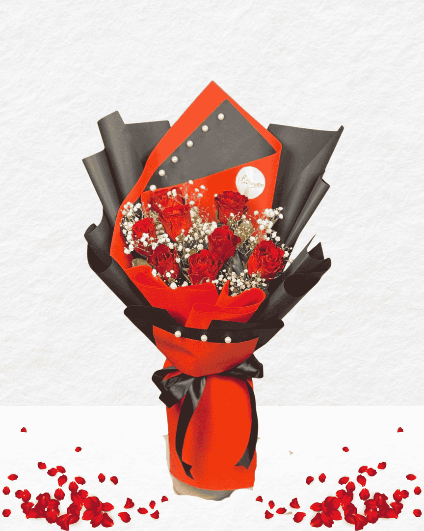 Bouquet of red roses wrapped in black and red paper with a card on a white background