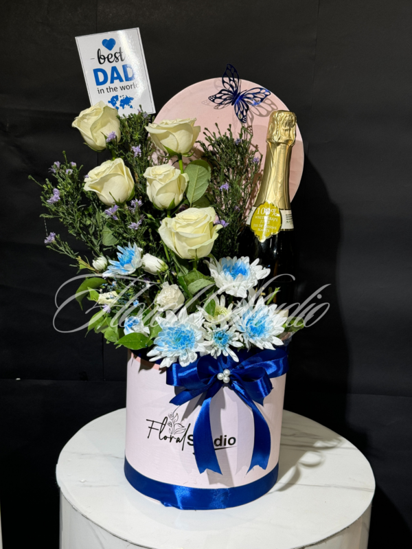 Dad's Delight floral gift arrangement with white roses, blue flowers, and champagne in a pink box with blue ribbon, perfect gift for Father's Day or special occasions