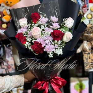 Majestic Bloom luxury bouquet featuring red roses, pink roses, pink chrysanthemums, baby’s breath, and greenery, wrapped in black and marble-patterned paper with a red satin ribbon.