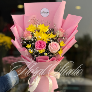 Elegant pink and yellow flower bouquet "Pink Bliss" featuring pink roses, yellow chrysanthemums, and baby’s breath wrapped in pink paper with a white satin ribbon.