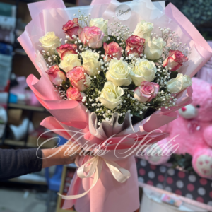 "Blushing Charm Bouquet featuring fresh pink and white roses with baby's breath, elegantly wrapped in soft pink paper and tied with a white ribbon, available for online flower delivery in Lahore and Bahria Town."